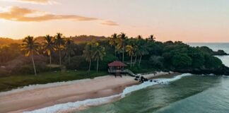 America’s Best Resorts with Private Beaches You Can Book Now a hidden crescent-shaped beach at sunset, soft orange light reflecting off calm waves, a single cabana tucked between palm trees.