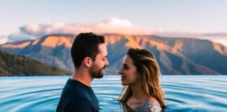 Couples’ Guide: Most Intimate Luxury Resorts in the USA a couple in a soft-lit infinity pool overlooking mountains during sunset.